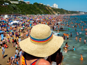Women wearing a straw sun hat on a crowded UK Beach