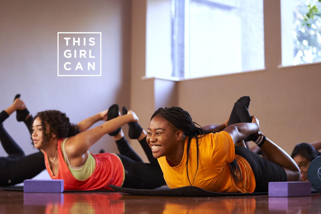 Young women stretching on gym mats enjoying a gym class