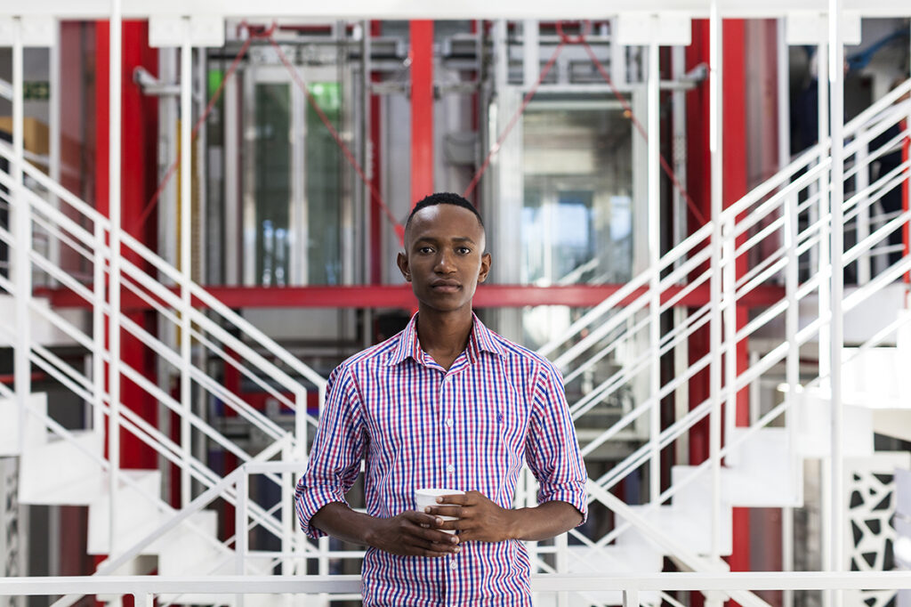 Multi-Location Photography, Visual Brand Library. A man standing in front of stairs holding a cell phone.