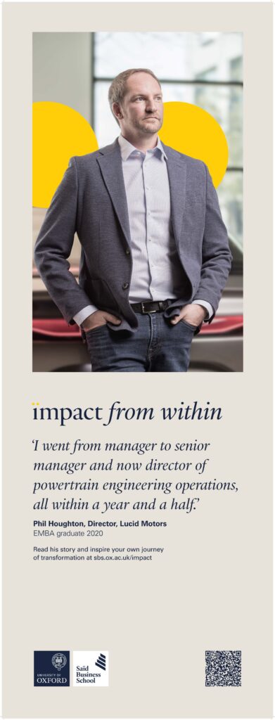 Oxford Alumni Portrait of Professional Man standing proudly in his car showroom