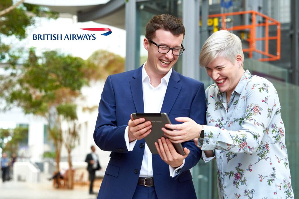 Smiling business couple outside looking at a digital tablet. Employee brand library photography.