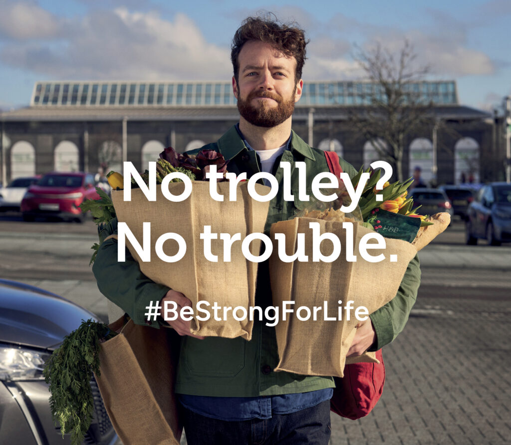 Lifestyle campaign image of man carrying groceries outdoors, part of multi-location production with coordinated logistics and budget management