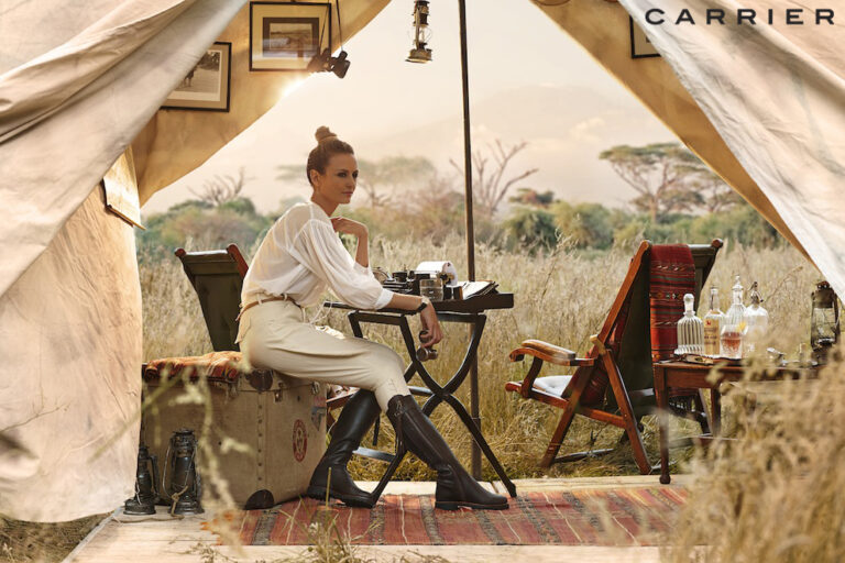 Safari-style travel image of couple walking through grassland, produced in UK location to recreate African destination for travel campaign