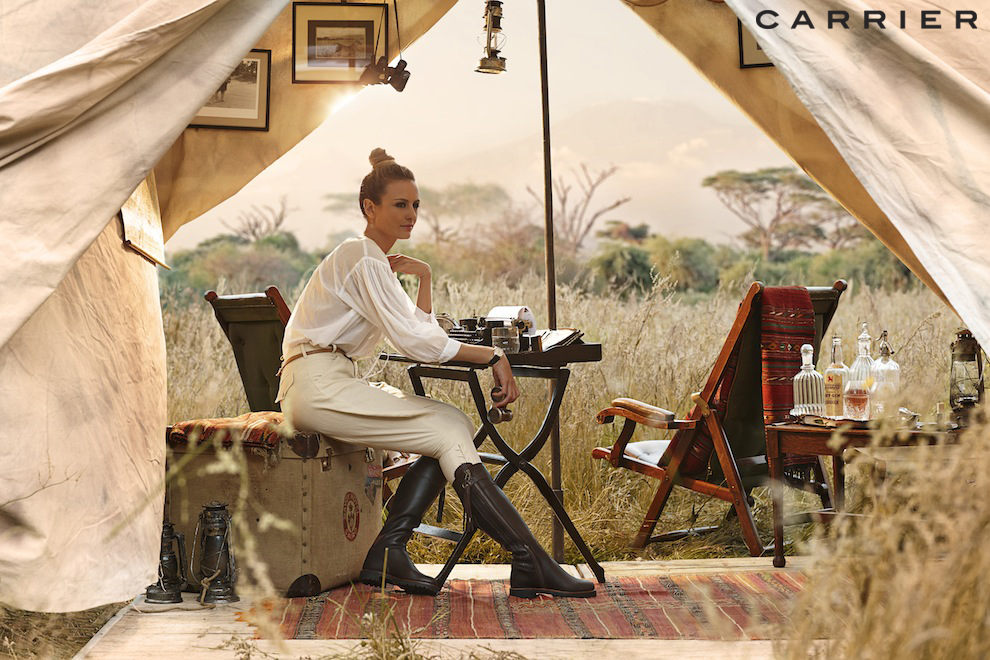 Safari-style travel image of couple walking through grassland, produced in UK location to recreate African destination for travel campaign